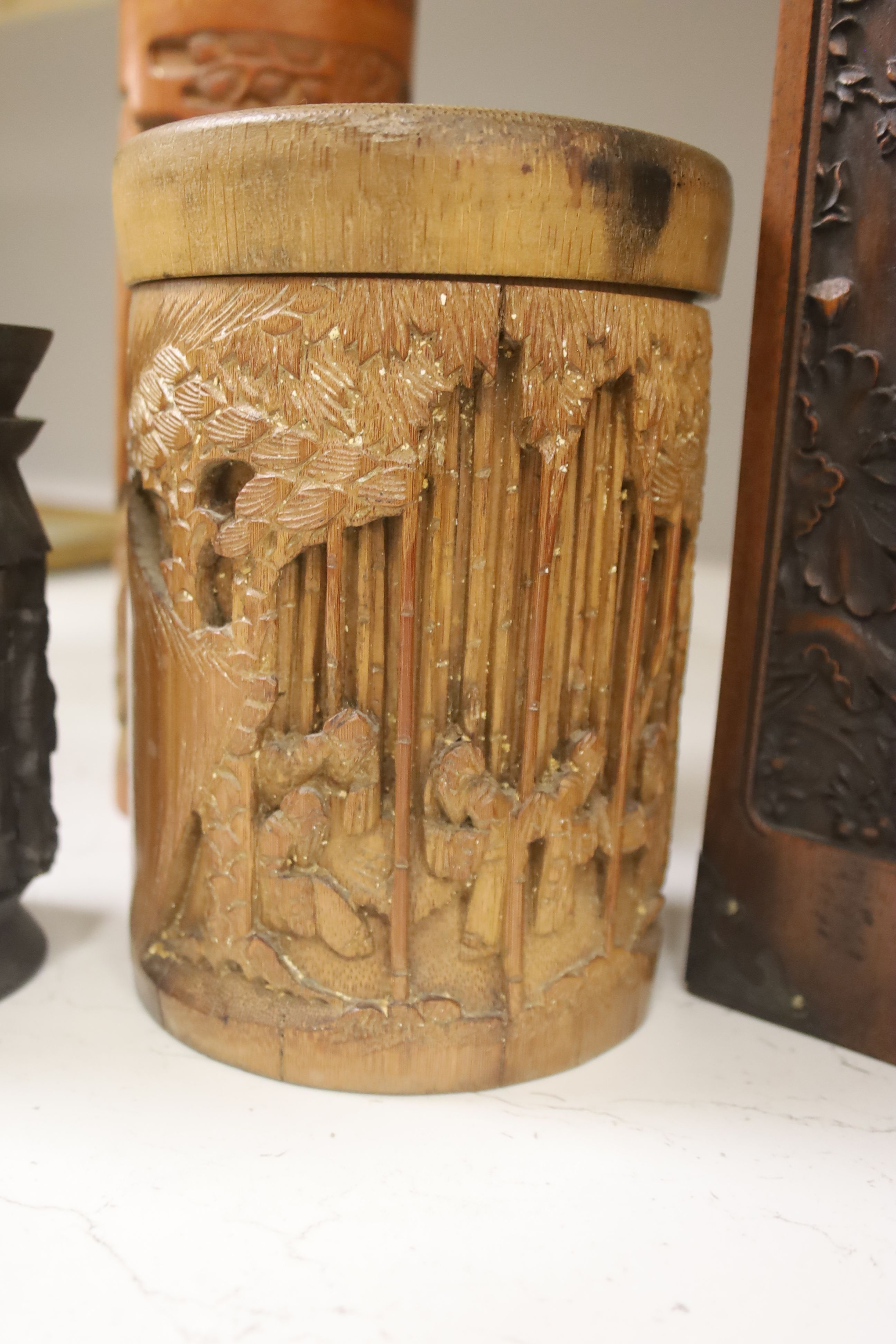 Three Chinese carved bamboo tea caddies and four carved bamboo brush pots